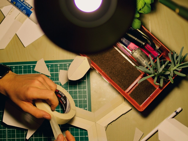 An overhead view of a desk with hands measuring an angle